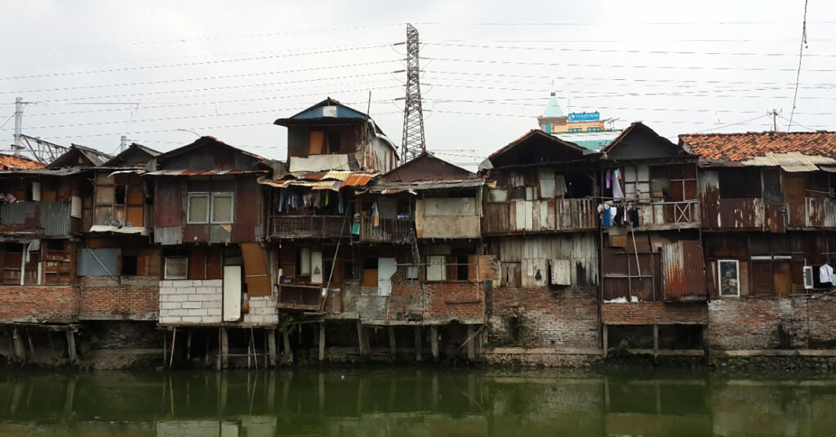 Precarious houses along polluted riverbank