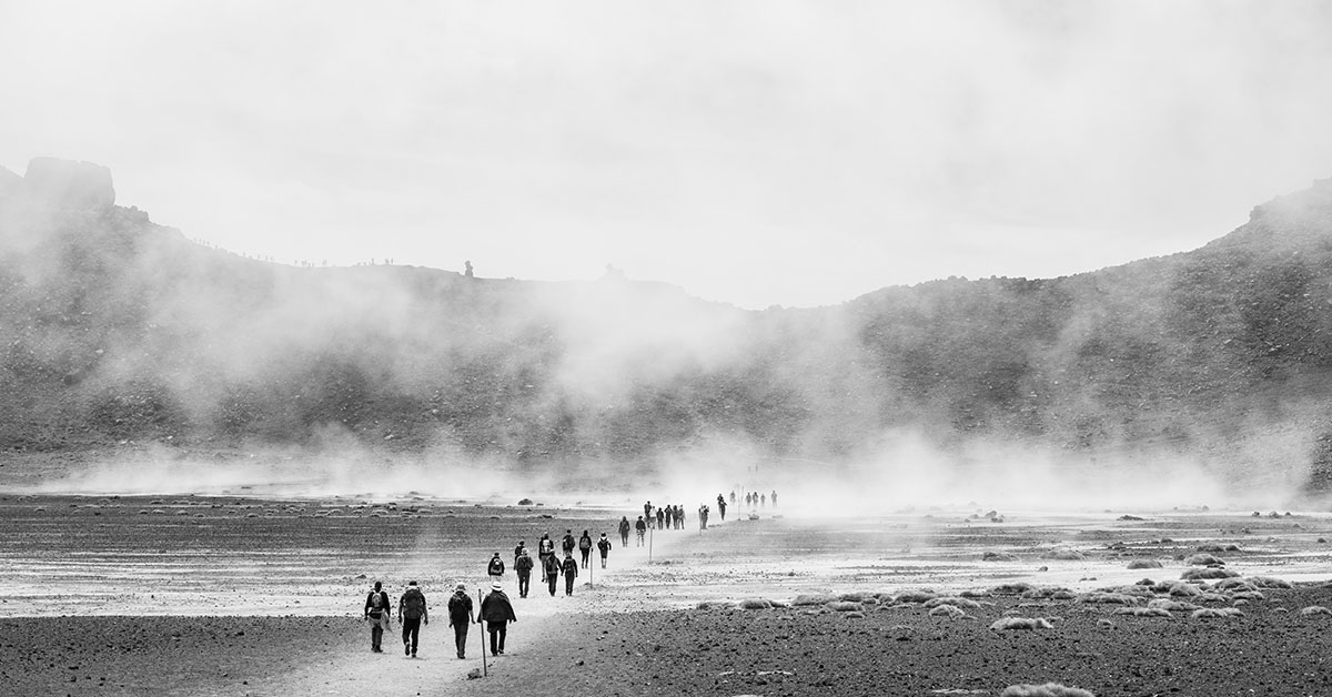 People walking through barren landscape